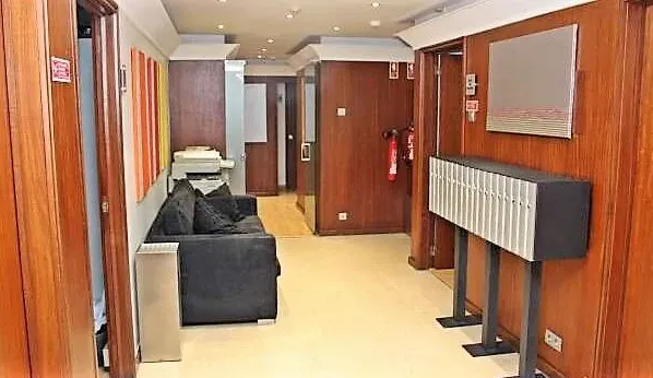 Corredor com portas de madeira e zona de espera